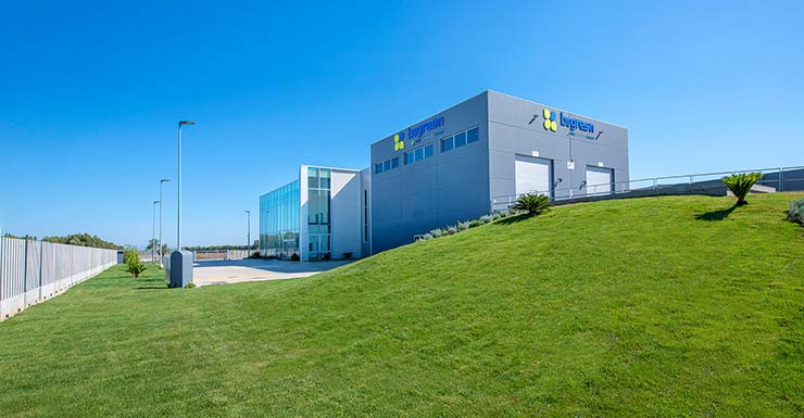 Impianto industriale moderno con edifici e prato verde sotto cielo azzurro, struttura dedicata a produzione di biometano in Sardegna